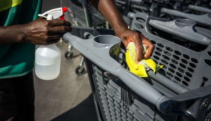 A worker sprays sanitiser on the handle of a shopping cart outside a Pick n Pay supermarket in Johannesburg.